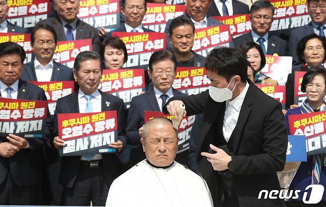 윤재갑 더불어민주당 의원이 지난달 30일 오전 서울 영등포구 여의도 국회 본관 앞 계단에서 열린 후쿠시마산 수산물 수입 반대 및 대일 굴욕외교 규탄대회에서 삭발을 하고 있다./뉴스1 ⓒ News1 임세영 기자