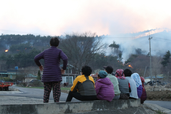 2일 오전 11시께 충남 홍성군 서부면에서 발생한 산불이 8시간 넘게 계속되자, 마을 주민들이 걱정하며 산불을 바라보고 있다. 연합뉴스