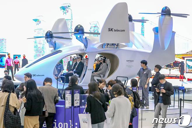 서울 강남구 코엑스에서 지난달 19일 열린 '2023 월드IT쇼'를 찾은 관람객들이 SK텔레콤의 도심항공교통(UAM) 체험을 하고 있다. ⓒ News1