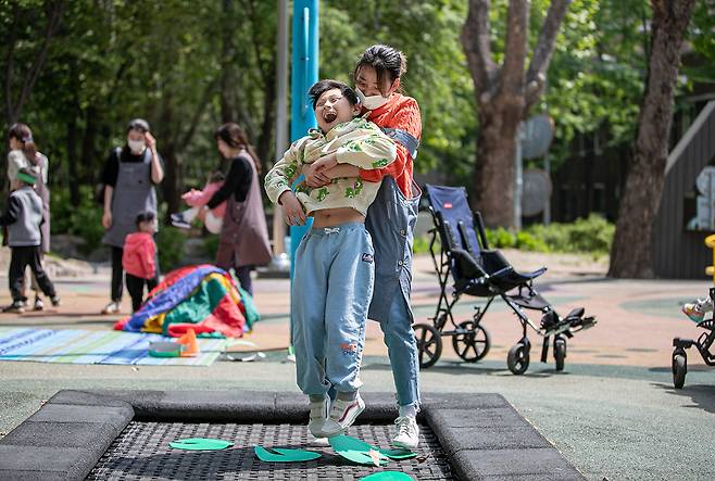 뇌병변 장애 아동 김연우 군(10)이 선생님에게 안겨 트램펄린을 타면서 환하게 웃고 있다. ⓒ시사IN 박미소