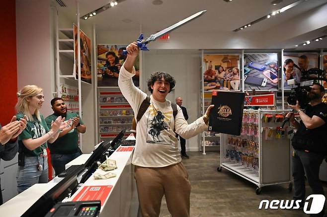 12일(현지시간) 미국 뉴욕에서 이날 6년 만에 출시된 '젤다의 전설' 신작을 구매한 첫 번째 손님 데이비드 카스티요가 마스터 소드를 휘두르며 활짝 웃고 있다. ⓒ AFP=뉴스1 ⓒ News1 권진영 기자