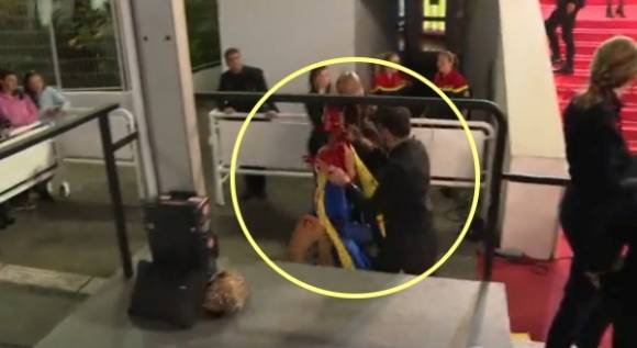 여성은 붉은색 액체를 뒤집어쓴 채 현장 보안 요원에게 이끌려 퇴장당했다. AP 연합뉴스