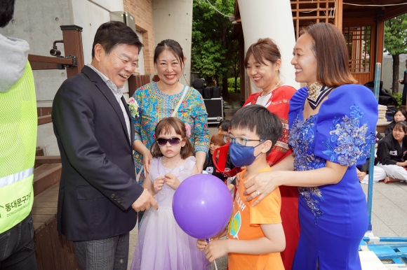 이필형(맨 왼쪽) 서울 동대문구청장이 지난 21일 동대문구 용두근린공원에서 열린 ‘세계가족축제’에서 다문화가정 주민들과 웃으며 인사하고 있다. 동대문구 제공