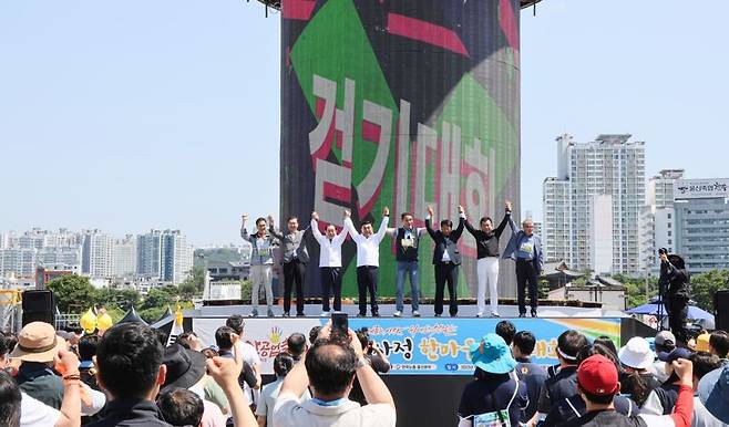 2023 울산공업축제와 연계한 한국노총 울산지역본부 노사민정 한마음 걷기대회가 2일 태화강 국가정원 남구 둔치 일원에서 열린 가운데 김두겸 울산시장, 김기환 시의회의장, 김충곤 한국노총 울산본부의장 등 참석자들이 손을 잡고 만세를 부르고 있다. 울산시 제공