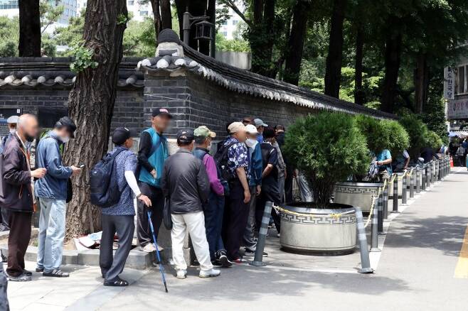 4일 서울 종로구 탑골공원 인근에서 노인들이 무료 배식을 받기 위해 줄지어 서 있는 모습.뉴시스