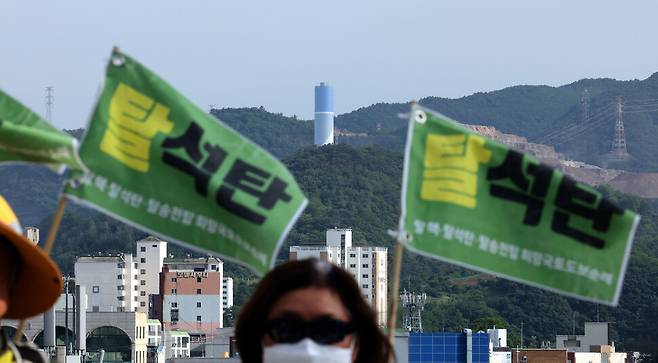 삼척석탄화력반대투쟁위원회 순례단 뒤로 석탄화력발전소 굴뚝이 선명하게 보인다. 박종식 기자