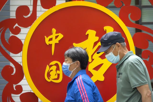 중국 베이징의 한 공원에서 지난 5월 마스크를 쓴 시민들이 '중국몽'이라고 쓰인 선전 광고판을 지나가고 있는 모습. AP연합뉴스