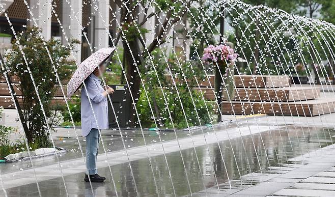 잠시 소나기가 내렸던 지난 8일 오후 서울 광화문광장에서 우산을 쓴 시민들이 분수대를 지나가고 있다. 연합뉴스