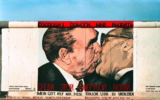 베를린 장벽 동쪽에 묘사된 두 사람의 키스 모습. 이 사진은 하나의 문화적 아이콘으로 자리 잡았다. <사진=Joachim F. Thurn>,  <저작권=Corbis Corporation>