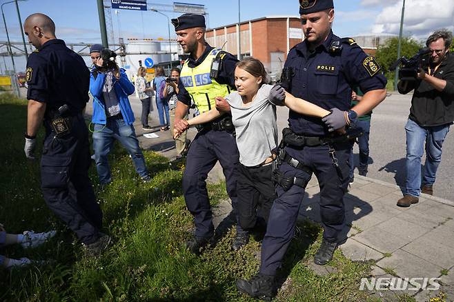 [말뫼=AP/뉴시스] 스웨덴 기후 운동가 그레타 툰베리가 24일(현지시각) 스웨덴 말뫼의 석유 시설 입구를 봉쇄한 혐의로 경찰에 연행되고 있다. 툰베리는 지난달 같은 곳에서 시위를 벌이던 중 교통에 방해가 된다는 이유로 장소를 옮기라는 경찰의 지시를 따르지 않은 '경찰 불복종' 혐의로 벌금형(약 30만 원)을 선고받은 지 불과 몇 시간 만에 다시 시위를 벌였다. 2023.07.25.