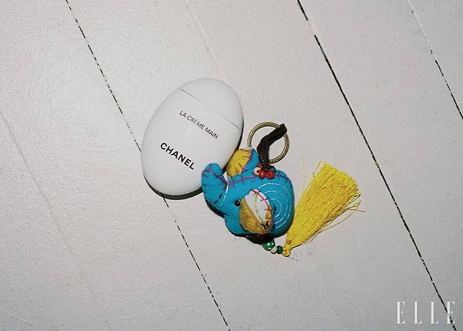 지우가 건조한 손이 싫어 늘 들고 다니는 핸드크림. 태국에서 구매한, 행복을 가져다주는 코끼리 인형 열쇠 고리.