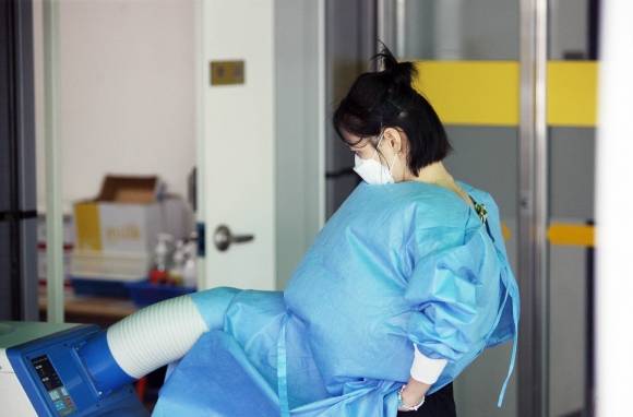 불볕더위가 지속되고 있는 8일 광주 북구 선별진료소에서 코로나19 의료진이 이동식 에어컨으로 더위를 식히고 있다. 연합뉴스