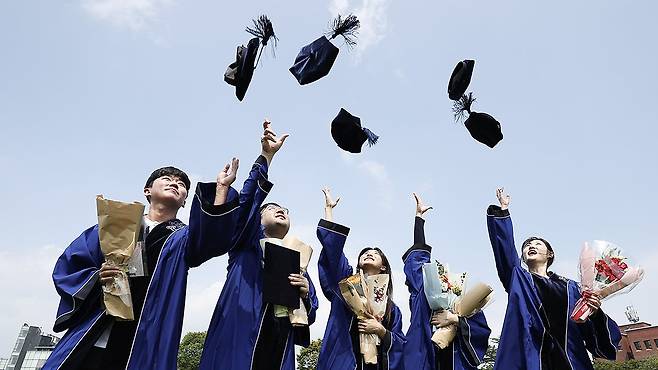 졸업생들이 학사모를 던지며 기념촬영을 하고 있다. 연합뉴스