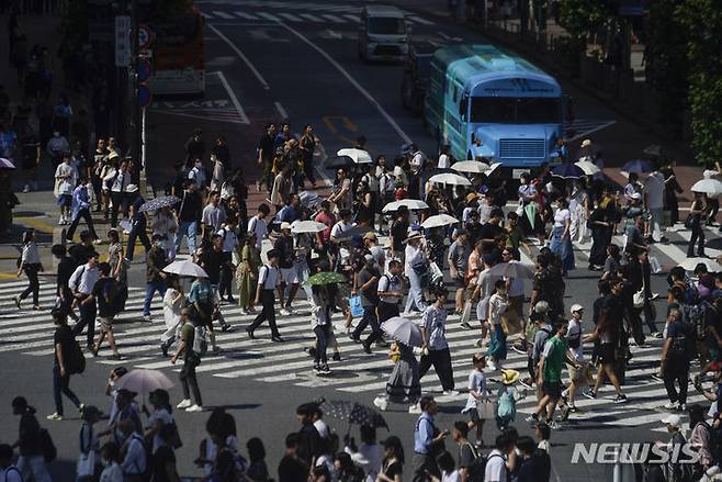[도쿄=AP/뉴시스]일본 수도 도쿄에서 지난 12일 시민들이 횡단보도를 건너고 있다. 2023.07.26.