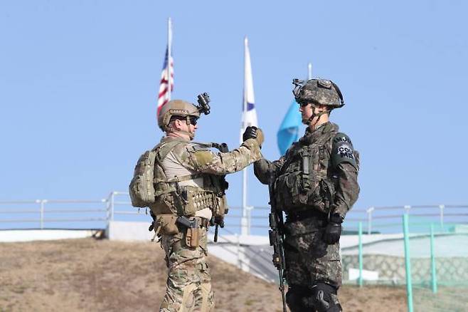 비무장지대 판문점 공동경비구역(JSA) 오울렛 경계소초에서 JSA경비대대 유재우 대위(진)와 유엔군사령부 경비대대 디킨스 중사가 한미연합 수색작전을 마친 뒤 악수하고 있다.