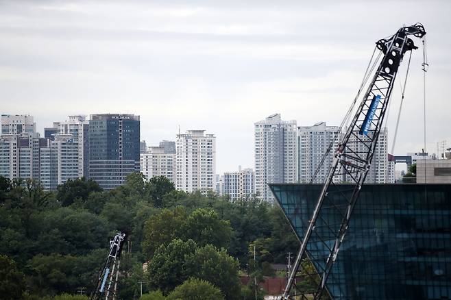 서울 시내의 한 주상복합 공사현장 크레인 너머로 주거단지가 보이고 있다. /뉴스1