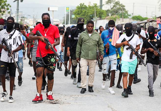 아이티 최대 갱단 두목 지미 셰리지에(가운데)가 지난 19일(현지시간) 포르토프랭스에서 부하들과 함께 총기를 들고 행진하고 있다. 로이터연합뉴스
