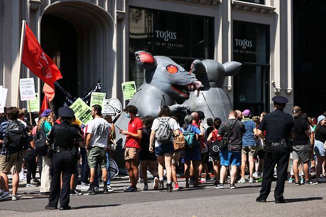아마존과 스타벅스 노동자들이 제프 베조스의 뉴욕 집 근처에서 시위를 벌이고 있다.  붉은눈의 거대한 쥐는 악덕고용주를 상징한다. 2022년9월. / 출처 : 게티이미지