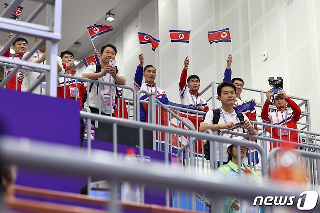 북한 사격대표팀이 26일 중국 항저우 푸양 인후 스포츠센터에서 열린 2022 항저우 아시안게임 사격 남자 10m 러닝타깃 혼합 개인 시상식에서 은메달을 획득한 북한 권광일이 시상대에 오르자 인공기를 흔들며 환호하고 있다. 2023.9.26/뉴스1 ⓒ News1 유승관 기자