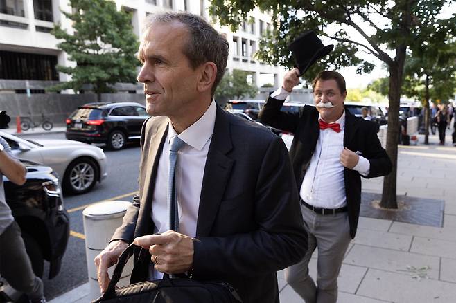 켄트 워커 알파벳 최고법률책임자(CLO)가 지난달 12일(현지시간) 미국 워싱턴DC 연방법원 출석길에 나서자 독점 사업가 분장을 한 시위자가 뒤따라 걸으며 항의 퍼포먼스를 벌이고 있다. AP연합뉴스