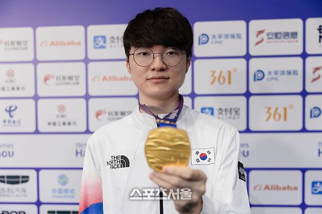 한국 LoL 대표팀의 맏형 ‘페이커’ 이상혁이 항저우 아시안게임 금메달을 들어보이고 있다. 사진 | 공동취재단