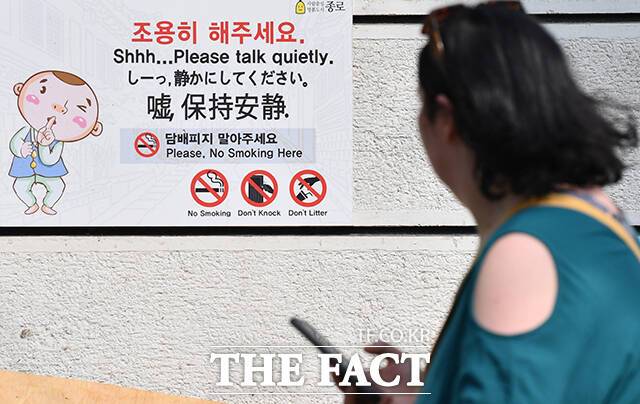 북촌한옥마을 담벼락에 '조용히 해주세요'가 쓰인 안내문이 붙어 있다.