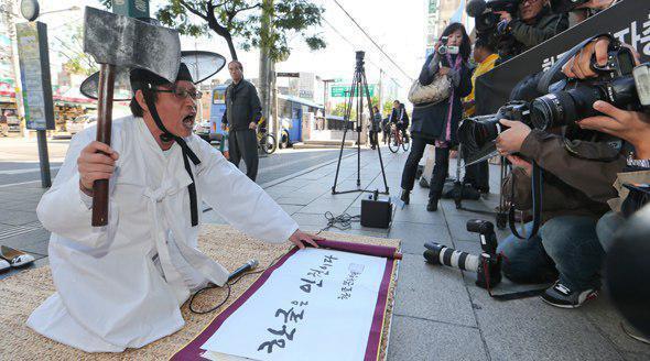 ▲ 2012년 10월30일 한국경영자총연합회 앞에서 도끼상소 시위를 벌이는 이건범 한글문화연대 대표. 사진=한글문화연대