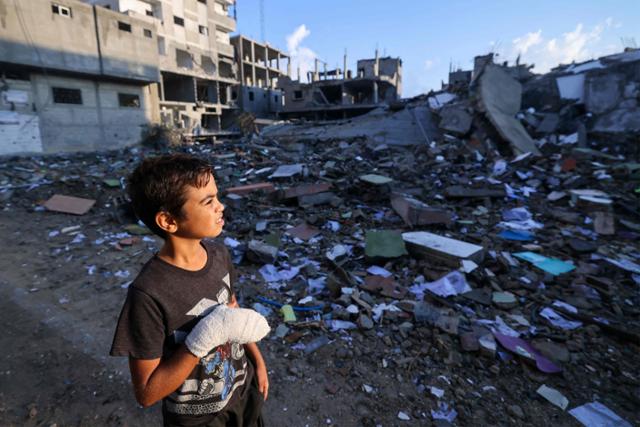 팔레스타인 12세 소년 모하메드 소피가 16일 가자지구 남부 라파 난민캠프에서 파괴된 건물을 바라보고 있다. 가자지구=AFP 연합뉴스