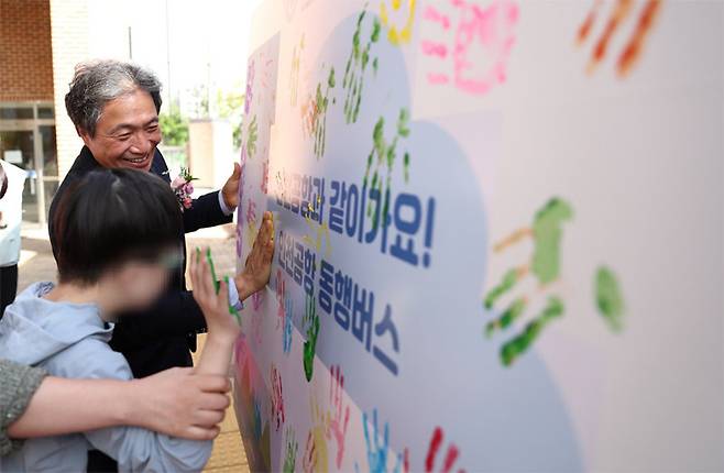 이학재 인천국제공항공사 사장이 6일 인천의 한 특수학교를 찾아 학생과 함께 동행버스에 부착할 손도장을 찍고 있다. 인천국제공항공사 제공