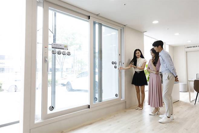 고객이 kcc글라스 홈씨씨 인테리어 전시장에서 홈씨씨 윈도우 제품을 살펴보고 있다.