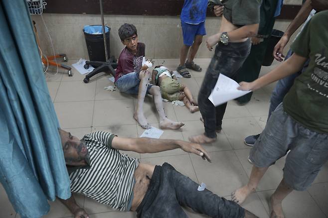 이스라엘의 가자 지구 폭격으로 부상당한 팔레스타인인들이 18일(현지시간) 데이르 알발라의 알아크사 병원 바닥에 누워 있다.  AP연합뉴스