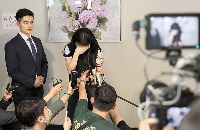 작년 5월 부산 부산진구 서면에서 20대 여성의 뒤를 따라가 무자비하게 폭행하고, 성폭행 후 살해하려 한 혐의로 기소된 피고인에게 12일 징역 20년이 선고됐다. 이날 부산고법 판결 직후 피해자(가운데)는 “가해자가 출소 후 보복하겠다고 하니 두렵다”며 눈물을 흘렸다. /연합뉴스