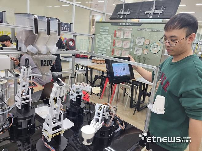 박준민 한국폴리텍대학 광주캠퍼스 기계시스템학과 학생이 꿈드림공작소에서 개발한 협동로봇 기반 커피 자동화 공정 시스템을 설명하고 있다.