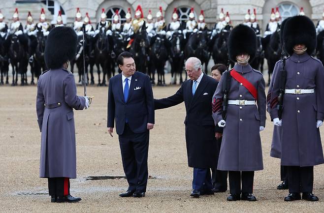 영국을 국빈 방문 중인 윤석열 대통령이 21일(현지시간) 런던 호스가즈 광장에서 열린 공식환영식에서 찰스 3세 국왕과 함께 의장대를 사열하고 있다./뉴시스