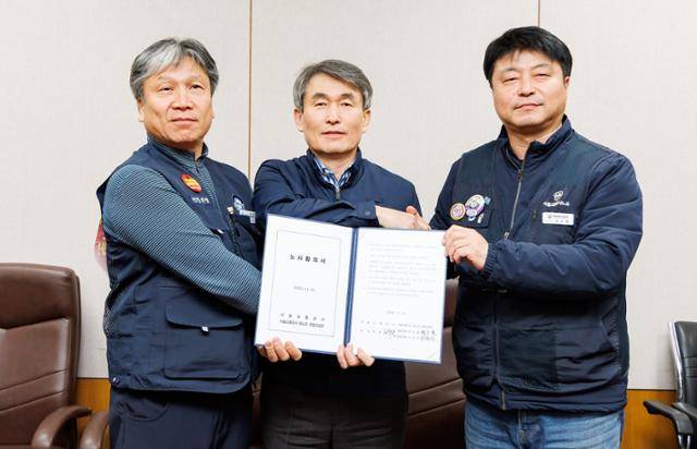 21일 서울 성동구 서울교통공사 본사에서 열린 임금 단체협상 노사 본교섭에서 이양섭 서울교통공사통합노동조합 위원장(왼쪽부터), 백호 서울교통공사사장, 명순필 서울교통공사노동조합 위원장이 노사합의서에 서명을 한 후 기념촬영을 하고 있다. 서울교통공사 제공