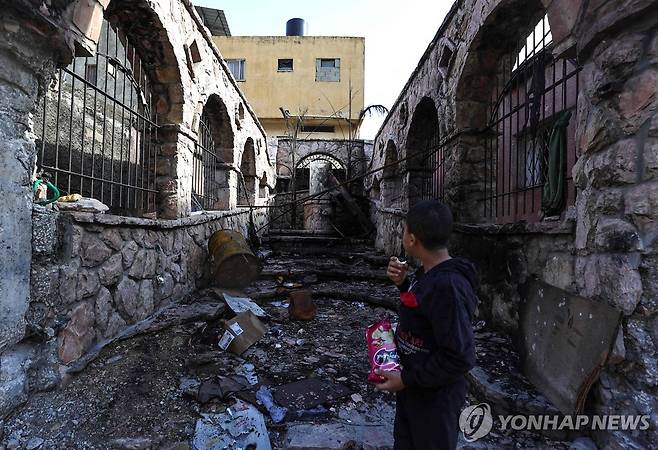 이스라엘 공습으로 파괴된 서안지구 난민촌 거리 (발라타 AFP=연합뉴스) 21일(현지시간) 요르단강 서안지구 발라타 난민촌에서 한 소년이 이스라엘 공습으로 파괴된 거리를 살펴보고 있다. 팔레스타인 무장 정파 하마스와 이스라엘 간 교전이 계속되는 가운데 이스라엘군이 서안지구 일부 지역도 사실상 봉쇄하고 있다. 2023.11.22 ddy04002@yna.co.kr