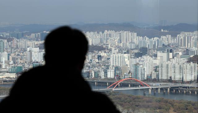26일 서울 영등포구 여의도 63빌딩 전망대에서 한 시민이 서울 시내를 내려다보고 있다. 뉴시스