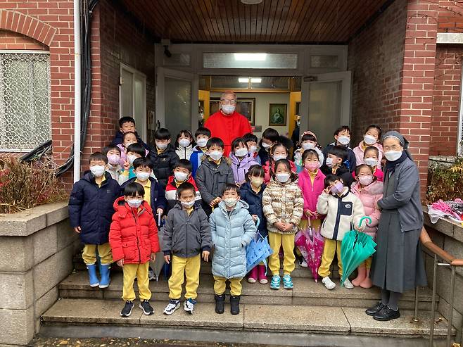 염수정 추기경이 30일 오전 이임 감사미사를 마치고 혜화동 주교관으로 옮겨 인근 혜화유치원생들의 환영을 받고 기념 촬영했다. /천주교 서울대교구