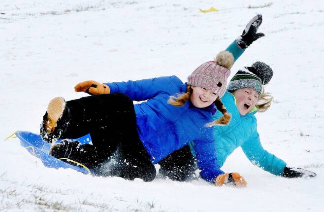지난 12월 미 중부 켄터키주에서 어린이들이 눈썰매를 타는 모습. 원래 눈이 많이 오는 뉴욕과 필라델피아, 워싱턴 DC 등 일명 'I-95 고속도로 통로'로 불리는 동부 해안엔 1월이 가도록 눈이 한 번도 안 오는 눈 가뭄이 이어지고 있다. /AP 연합뉴스