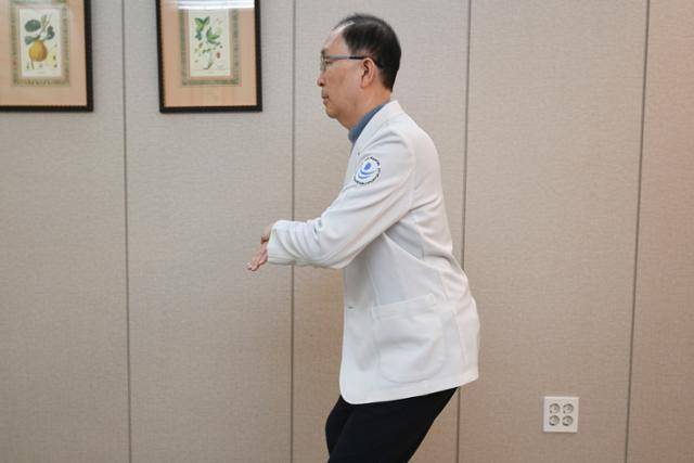 미니 스쿼트 자세다. 스포츠재활전문의인 나영무 솔병원 원장이 11월 30일 서울 강서구 솔병원에서 '백세 운동' 시범을 보이고 있다. 윤서영 인턴기자