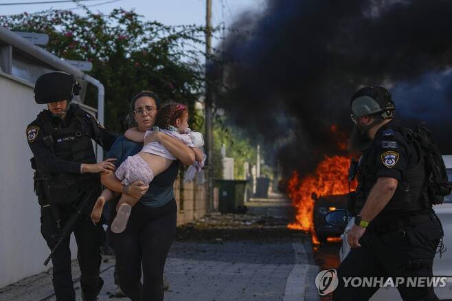하마스 로켓 공격에…아이 안고 대피하는 이스라엘 여성 (아슈켈론[이스라엘] AP=연합뉴스) 이스라엘 여성이 7일(현지시간) 팔레스타인 무장정파 하마스의 로켓 공격을 받은 남부 도시 아슈켈론에서 아이를 안고 대피하고 있다. 이스라엘군은 하마스의 기습 공격으로 이스라엘 국민 700명 이상이 사망하고 1천200여명이 부상했다고 9일 밝혔다. [자료사진] 2023.10.09 clynnkim@yna.co.kr
