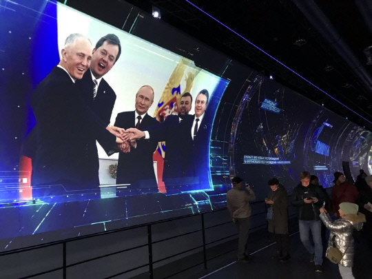 지난달 8일(현지시간) 러시아 모스크바 베데엔하(VDNkh) 박람회장에서 열린 '러시아 국제 전시 포럼'의 전시장에서 한 어린이가 블라디미르 푸틴 러시아 대통령이 나오는 영상을 사진에 담고 있다. 사진=연합뉴스