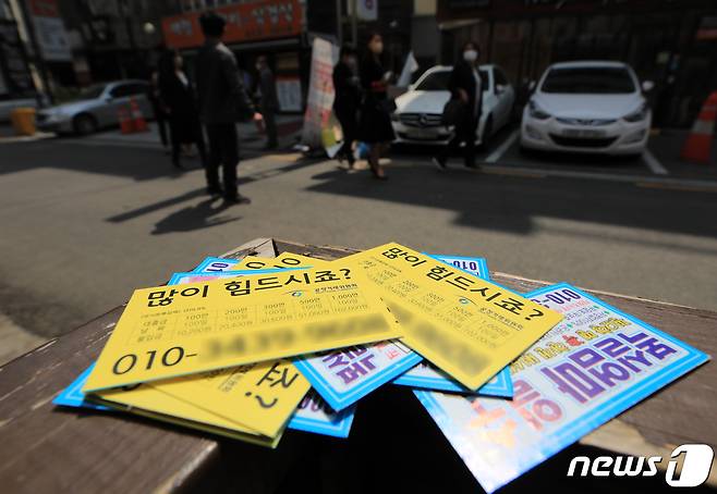 19일 오후 서울의 한 유흥가에 불법대부업 전단지가 흩뿌려져 있다. 서울시는 2017년 10월 전국 최초로 개발한 일명 '대포킬러'(불법 전화번호에 무제한 자동발신 프로그램) 운영을 통해 지금까지 불법 대부전화번호 총 2만1000여건을 차단했다고 밝혔다. 2022.4.19/뉴스1 ⓒ News1 구윤성 기자