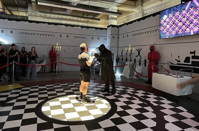 6일 오후(현지시간) 미국 로스앤젤레스(LA)에 개장한 '오징어 게임' 체험 공간에서 게임 우승자가 축하받고 있다. 연합뉴스