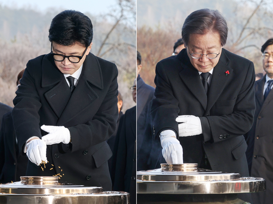 Left, Han Dong-hoon, People Power Party's interim leader, and Lee Jae-myung, Democratic Party leader, shows respect at the Memorial Tower at the Seoul National Cemetery in Dongjak District, Seoul, on Monday. [NEWS1]
