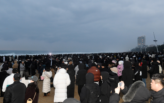 Visitors at Gyeongpo Beach in Gangwon wait for the New Year’s first sunrise on Monday morning. Regions alongside the East Sea missed the clear sunrise due to low clouds formed above the ocean waters. [YONHAP]