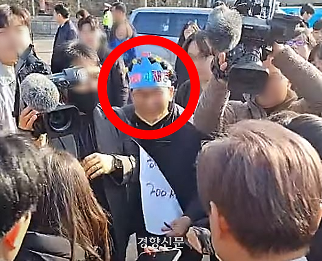 2일 부산 가덕도에서 파란색 종이 왕관을 쓴 남성(가운데)이 더불어민주당 이재명 대표(왼쪽 아래)를 향해 다가가고 있다. 유튜브 정양일TV 갈무리