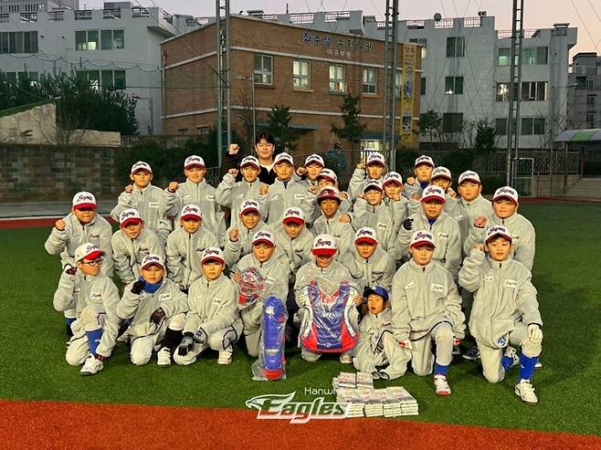 노시환이 부산 수영초등학교를 찾아 동계 의류와 야구용품을 선물하고 기념촬영하고 있다. 사진 | 한화 이글스