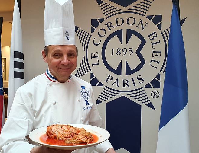 세계 3대 요리학교 중 하나인 프랑스 파리의 ‘코르동블뢰’의 에릭 브리파르 교장이 11일 김치 한 포기가 담긴 접시를 들고 미소를 짓고 있다. /손진석 특파원