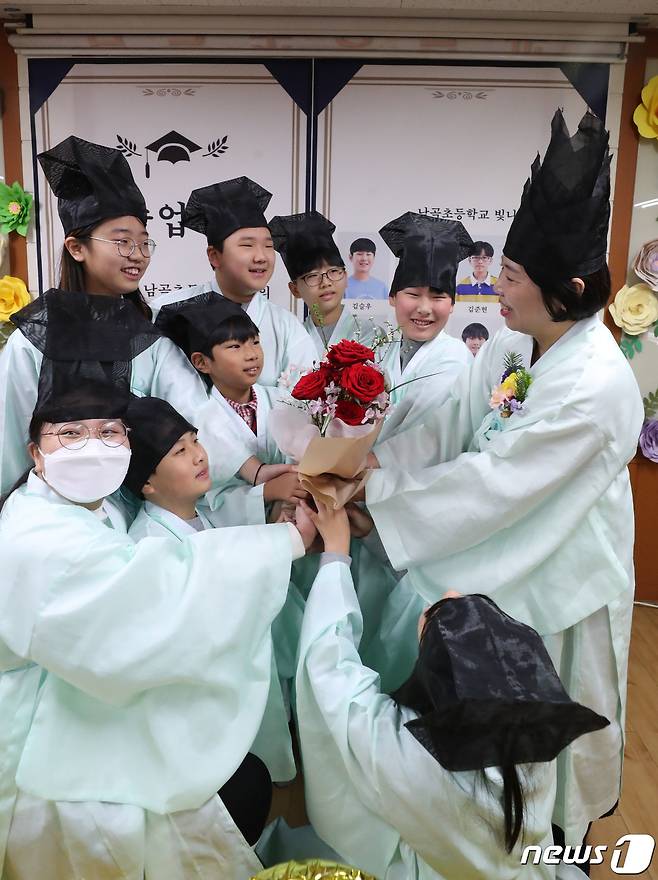 5일 오전 경기 용인시 처인구 남곡초등학교 제2캠퍼스에서 6학년 1반 학생들이 졸업식을 마치고 담임선생님과 기념촬영을 하고 있다. 남곡초등학교 남곡분교는 이날 졸업하는 8명의 학생을 끝으로 폐교된다. 2024.1.5/뉴스1 ⓒ News1 김영운 기자